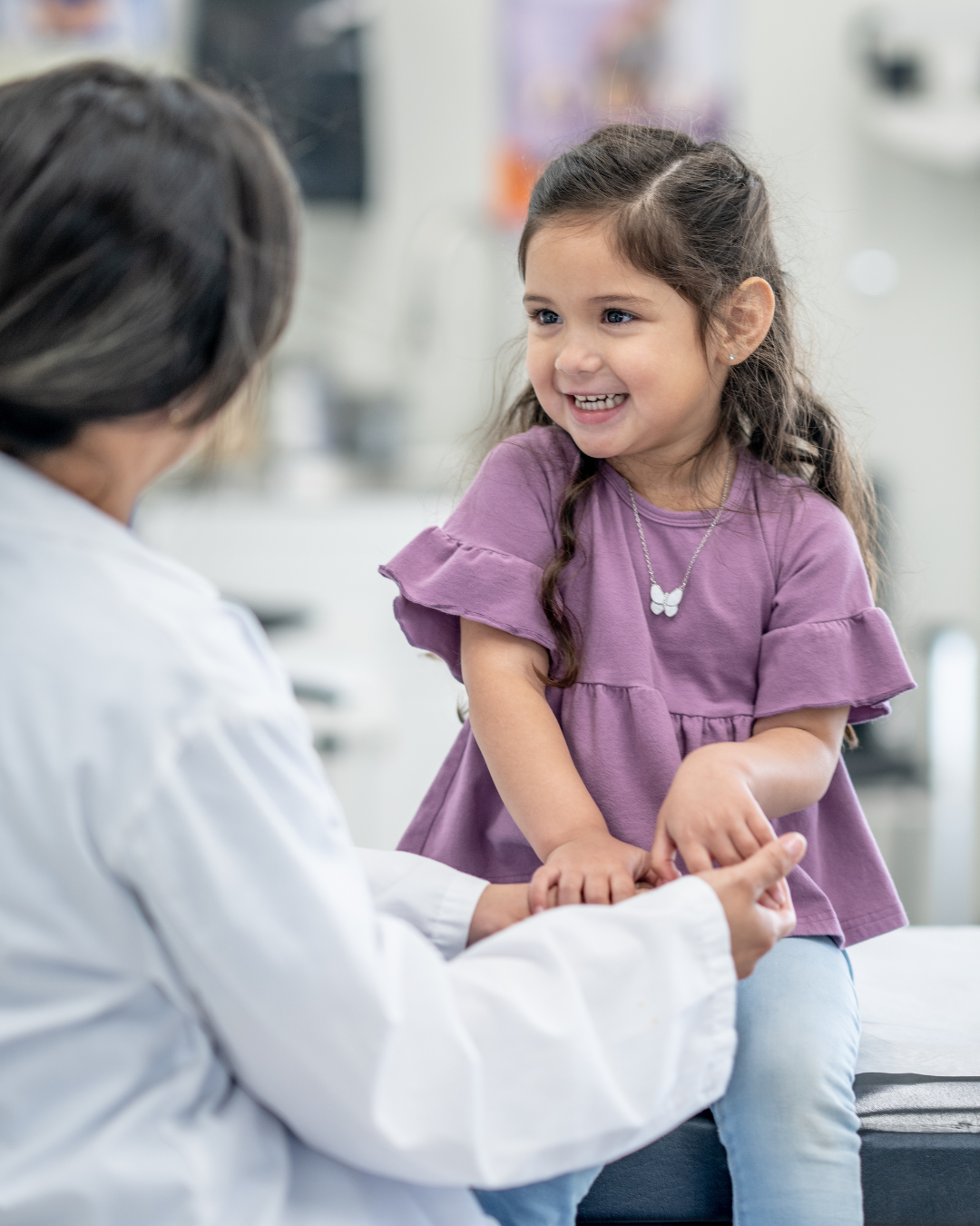 Enfant souriant rassuré par un professionnel de santé lors d’un examen d’imagerie médicale dans un centre de radiologie